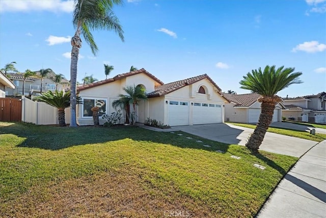 mediterranean / spanish-style house with an attached garage, fence, concrete driveway, stucco siding, and a front yard