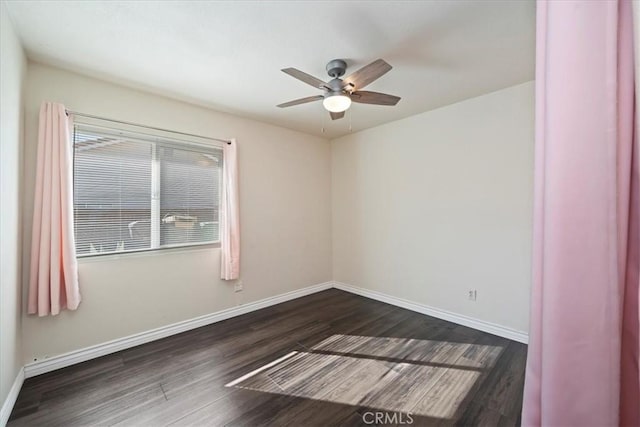 empty room with dark wood-style floors, ceiling fan, and baseboards