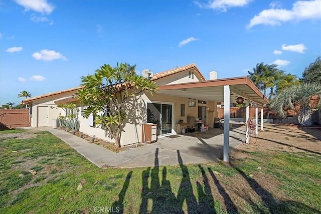 back of property featuring a lawn, fence, an outdoor structure, a patio area, and stucco siding