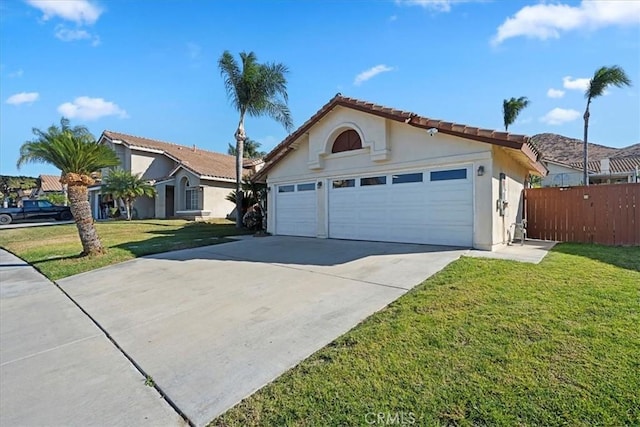 view of front of property with a garage, fence, driveway, stucco siding, and a front lawn