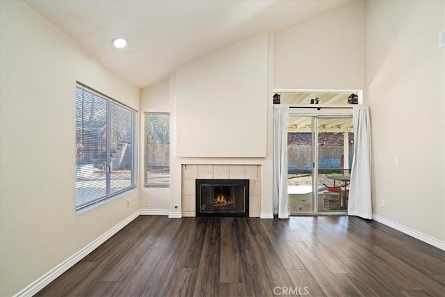 unfurnished living room featuring a tile fireplace, wood finished floors, and baseboards