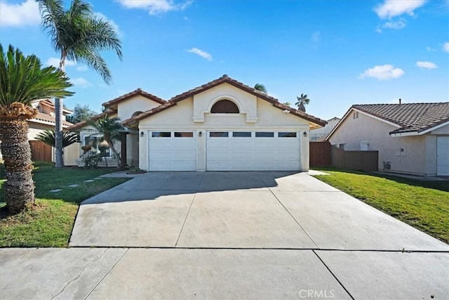 view of front of property with a front yard, driveway, an attached garage, and fence