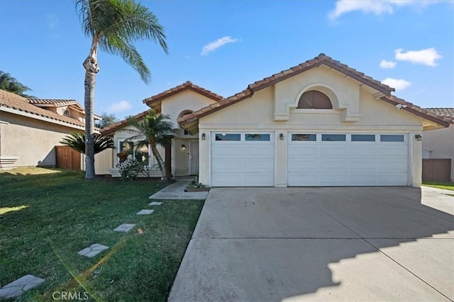 mediterranean / spanish-style house with an attached garage, driveway, a front lawn, and stucco siding