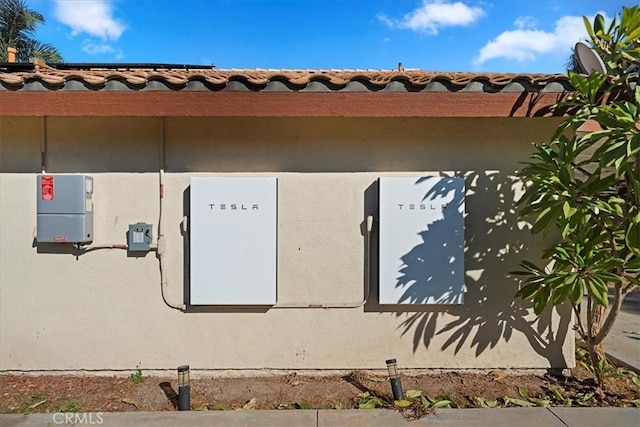 exterior details featuring a tiled roof and stucco siding