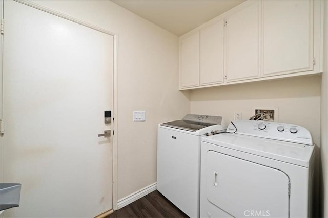 laundry area with dark wood finished floors, washing machine and dryer, cabinet space, and baseboards