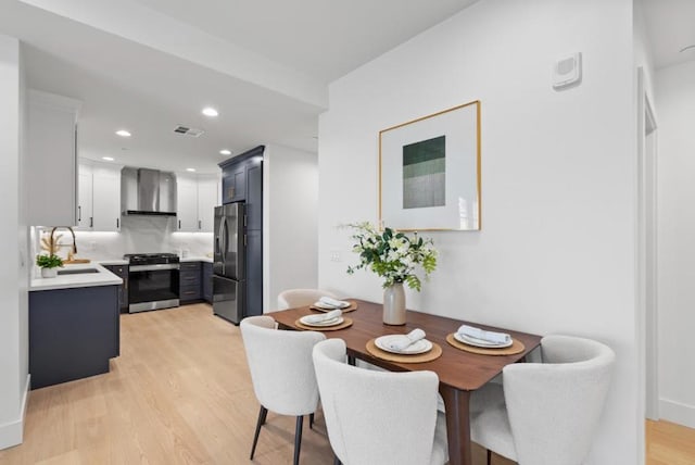 dining space with light hardwood / wood-style flooring and sink