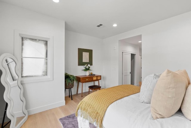 bedroom with light hardwood / wood-style floors and a closet