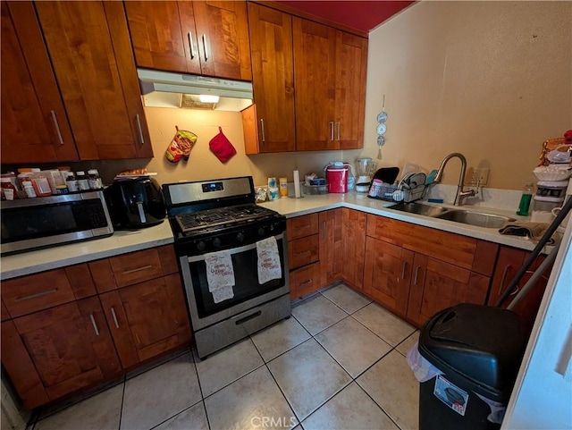 kitchen with appliances with stainless steel finishes, sink, and light tile patterned floors