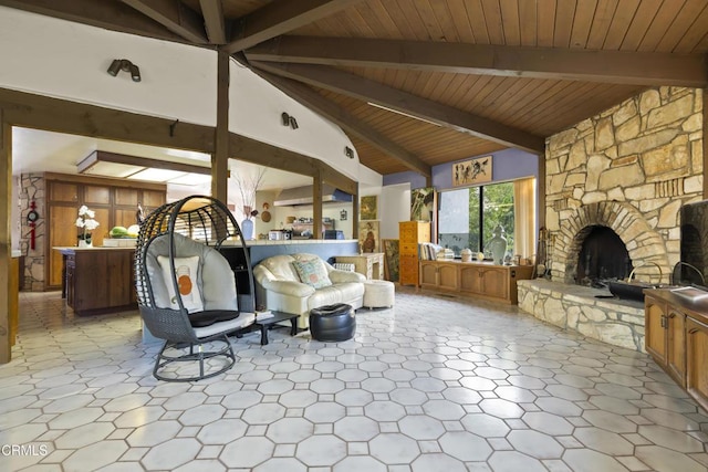 living room featuring lofted ceiling with beams, wood ceiling, and a stone fireplace