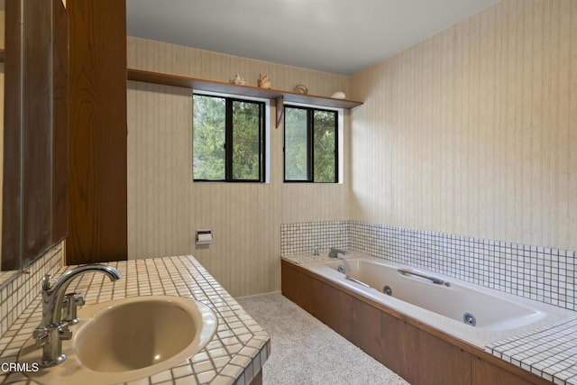 bathroom featuring sink and a tub to relax in