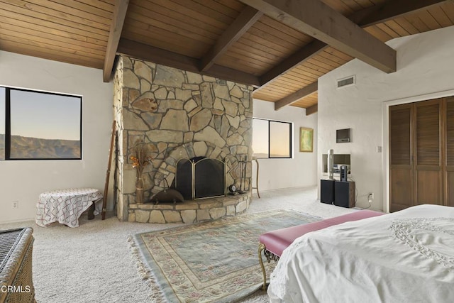 bedroom featuring wooden ceiling, a stone fireplace, carpet, a closet, and beam ceiling