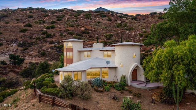 back house at dusk with a mountain view