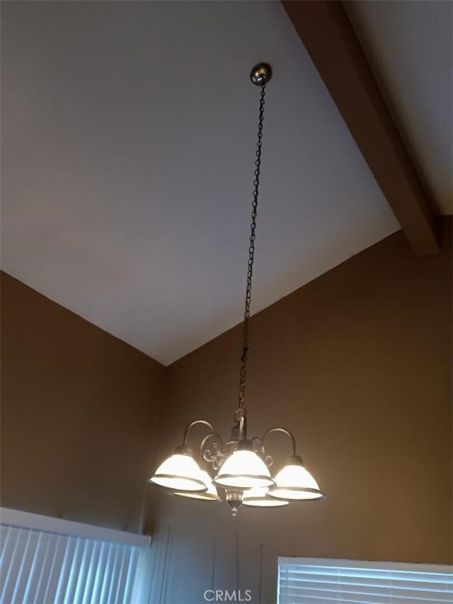 room details with beam ceiling and a chandelier