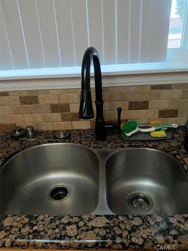 details featuring dark stone countertops, sink, and decorative backsplash