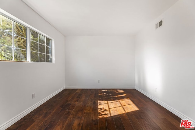 unfurnished room with dark hardwood / wood-style flooring