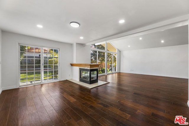 unfurnished living room with a multi sided fireplace, wood-type flooring, vaulted ceiling with beams, and a healthy amount of sunlight