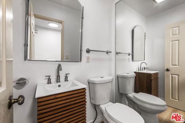 bathroom featuring hardwood / wood-style flooring, vanity, and toilet