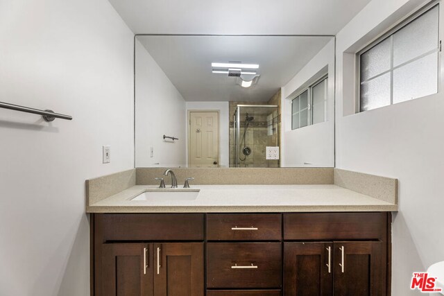 bathroom featuring vanity and a shower with door