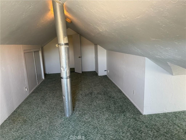 additional living space with vaulted ceiling and dark carpet