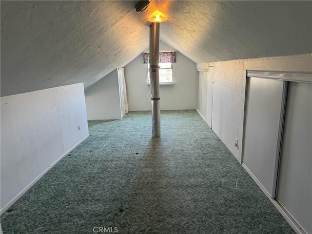 bonus room with lofted ceiling, carpet flooring, and a textured ceiling