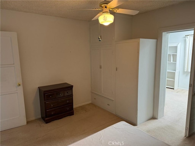 carpeted bedroom with ceiling fan and a textured ceiling