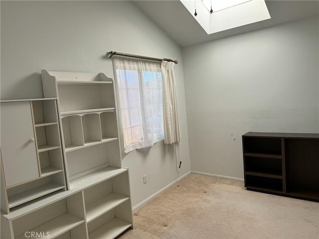 interior space featuring light carpet and lofted ceiling with skylight