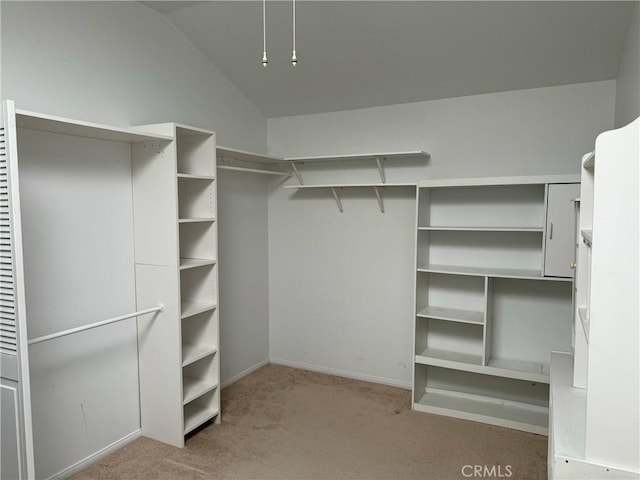 spacious closet featuring light colored carpet and lofted ceiling