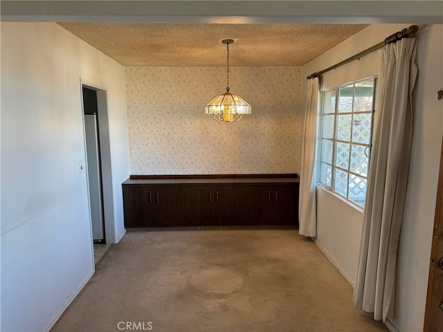 unfurnished dining area featuring light colored carpet and a chandelier