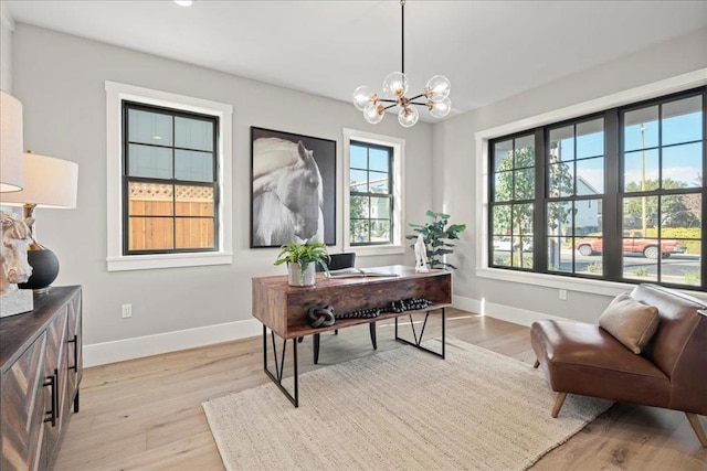 home office with a notable chandelier, light hardwood / wood-style flooring, and plenty of natural light