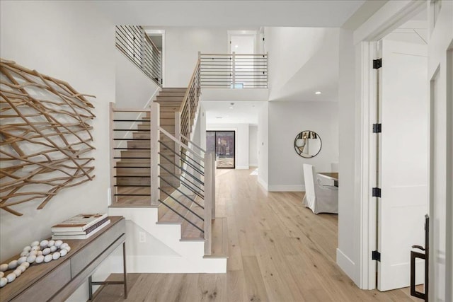 entrance foyer with a towering ceiling and light wood-type flooring