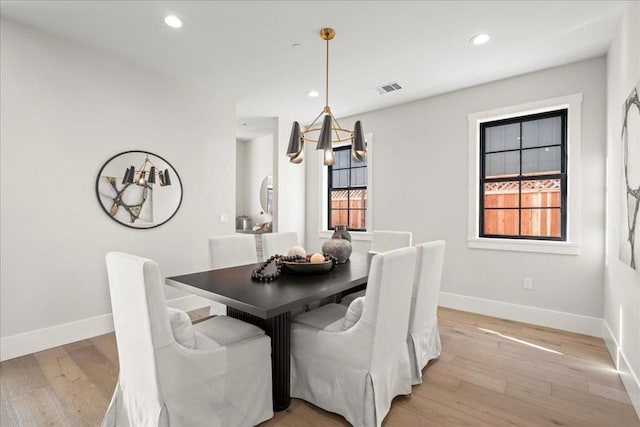 dining area featuring a notable chandelier and light hardwood / wood-style floors