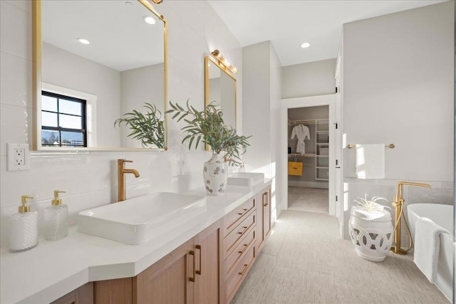 bathroom featuring tile walls, a tub, tasteful backsplash, and vanity