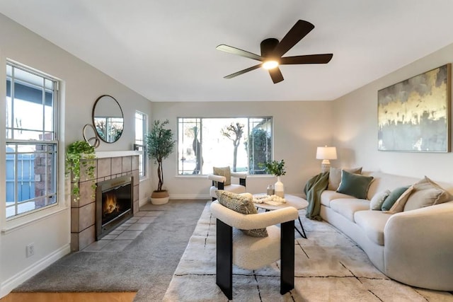 carpeted living room featuring ceiling fan and a fireplace