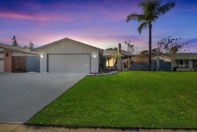 single story home featuring a garage and a lawn