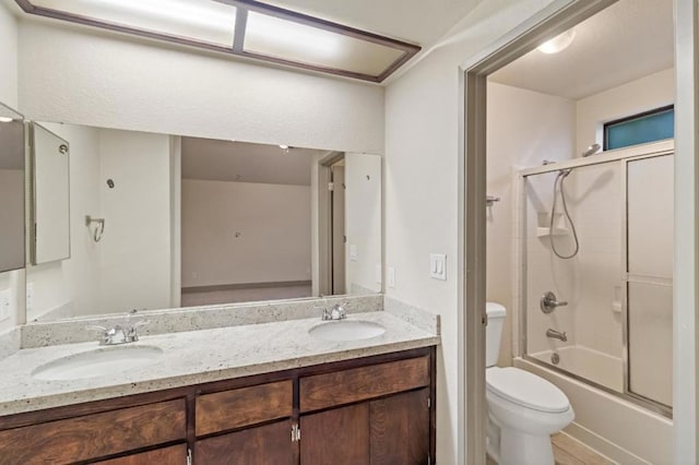 full bathroom featuring toilet, vanity, and combined bath / shower with glass door