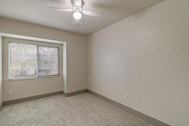 carpeted spare room with ceiling fan