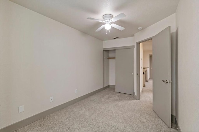 unfurnished bedroom with ceiling fan and a closet