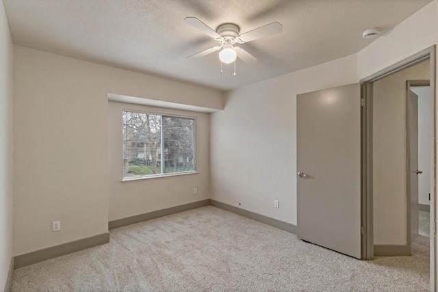 unfurnished bedroom with ceiling fan and light colored carpet