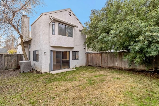 rear view of property featuring a lawn and central AC unit