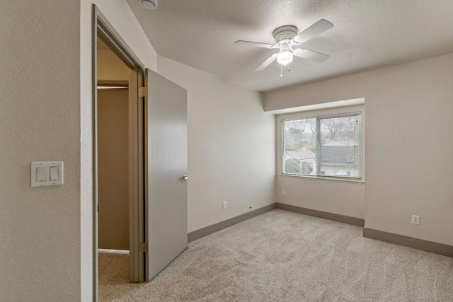 unfurnished bedroom with light carpet, ceiling fan, and a spacious closet