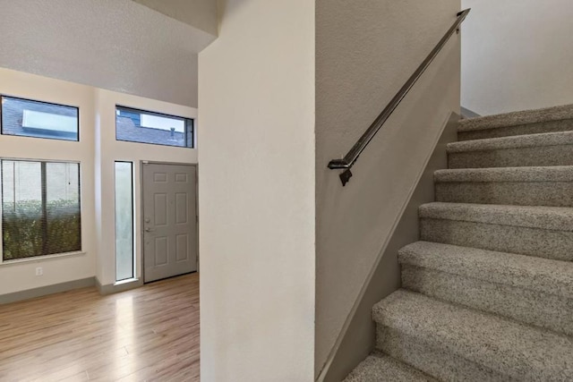 foyer entrance with a towering ceiling and light hardwood / wood-style floors