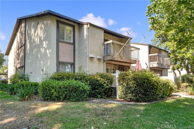 exterior space featuring a balcony and a lawn