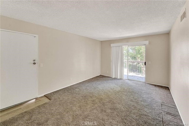 unfurnished room featuring carpet flooring and a textured ceiling