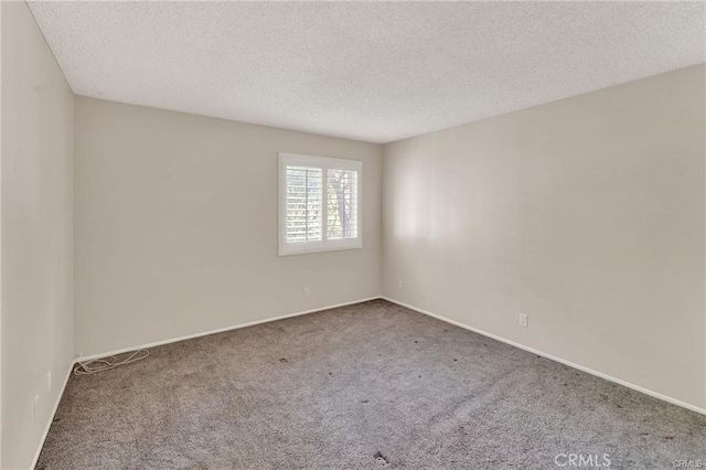 unfurnished room featuring carpet flooring and a textured ceiling