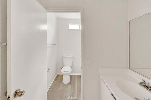 bathroom featuring toilet, vanity, and hardwood / wood-style floors