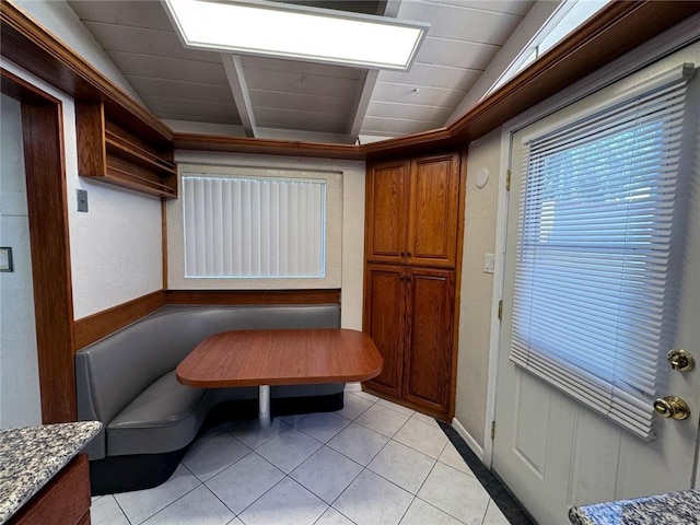 dining area with lofted ceiling and light tile patterned floors