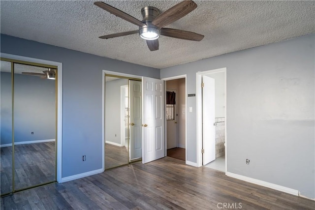 unfurnished bedroom with a textured ceiling, connected bathroom, ceiling fan, a closet, and dark wood-type flooring