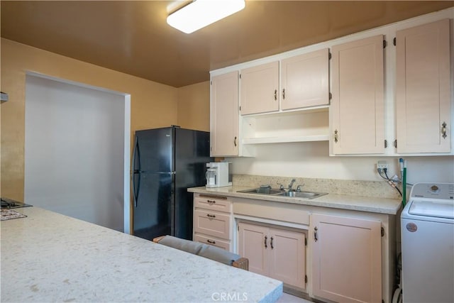 kitchen featuring white cabinets, washer / clothes dryer, black appliances, and sink