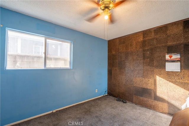 spare room featuring a textured ceiling, carpet floors, and ceiling fan