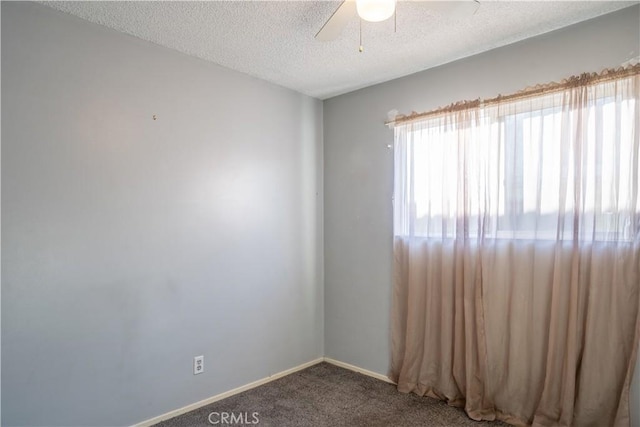 carpeted spare room featuring a textured ceiling and ceiling fan